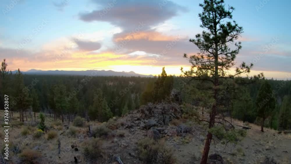 Sunset Aerial flying by trees and rocks toward mountain range in Oregon. Sunset Aerial flying by trees and rocks toward mountain range in Oregon.