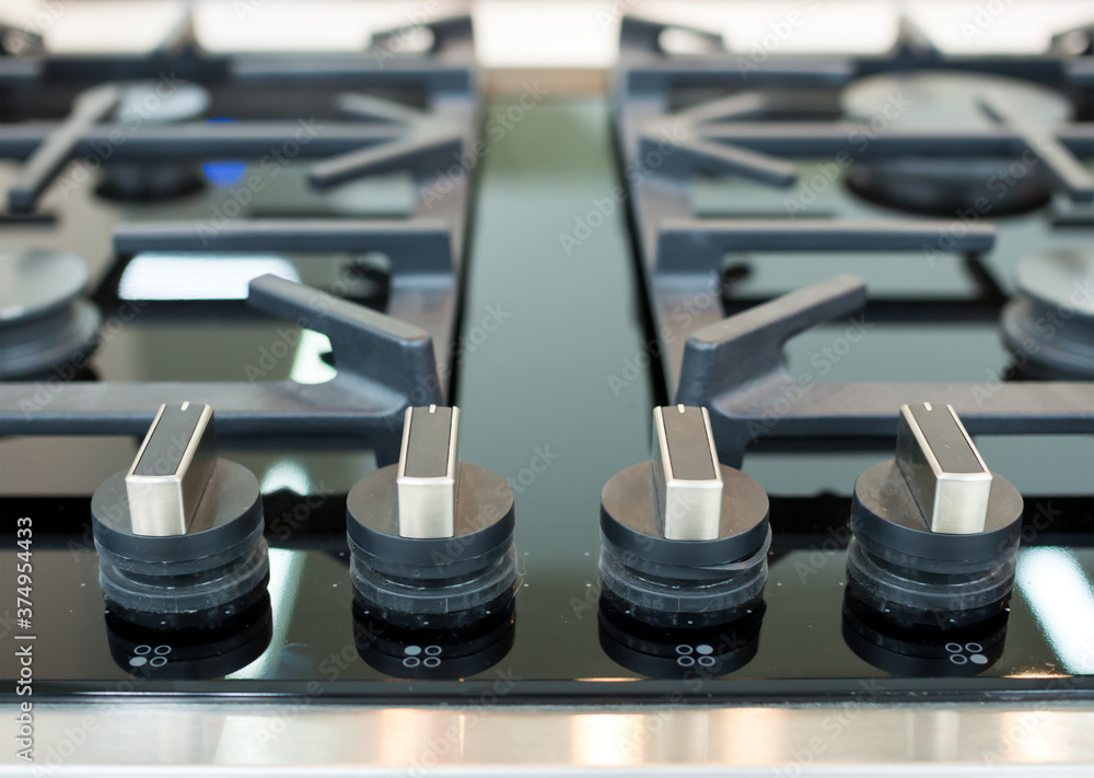 Detail of a modern gas hob with round handles Detail of a modern gas hob with round handles