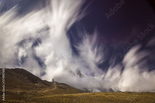 Long exposure picture of fast-moving clouds and blue sky over Himalayan mountains