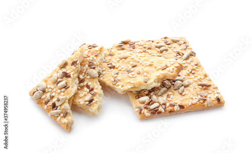 Broken crispy crackers with different seeds isolated on white