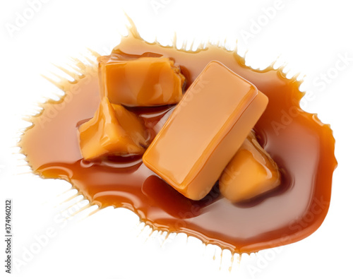 Composition of soft caramel candies isolated on white background, top view. Sweet caramel pieces with sauce or  maple syrup