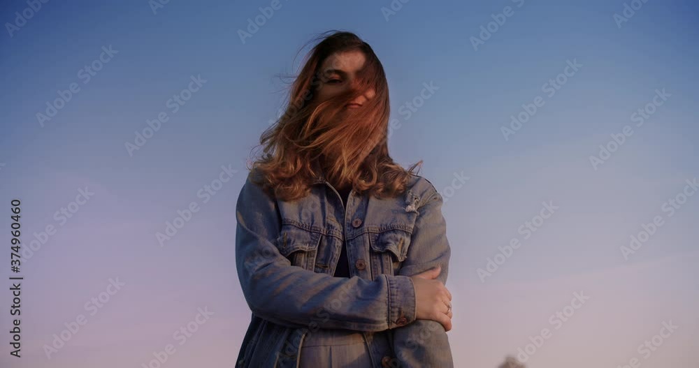 Portrait of happy young woman enjoying peaceful sunset on rooftop with wind blowing hair.Carefree holiday and happy active lifestyle. Portrait of happy young woman enjoying peaceful sunset on rooftop with wind blowing hair.Carefree holiday and happy active lifestyle.