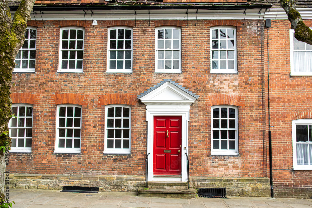 English house with red bricks, white windows and red door, England English house with red bricks, white windows and red door, England