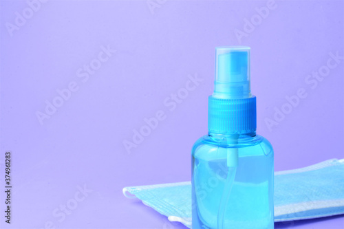 Close up, hygienic measures, hydroalcoholic gel and surgical masks, on a blue background 