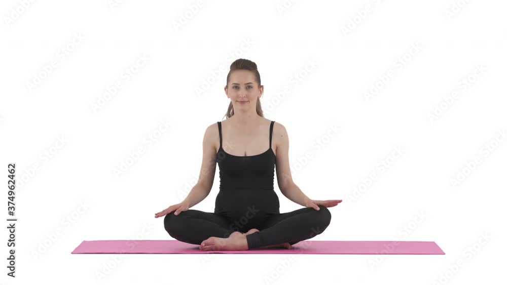 Prenatal yoga. Caucasian pregnant woman sitting cross-legged on mat and pressing legs down. Isolated on white background. Prenatal yoga. Caucasian pregnant woman sitting cross-legged on mat and pressing legs down. Isolated on white background.