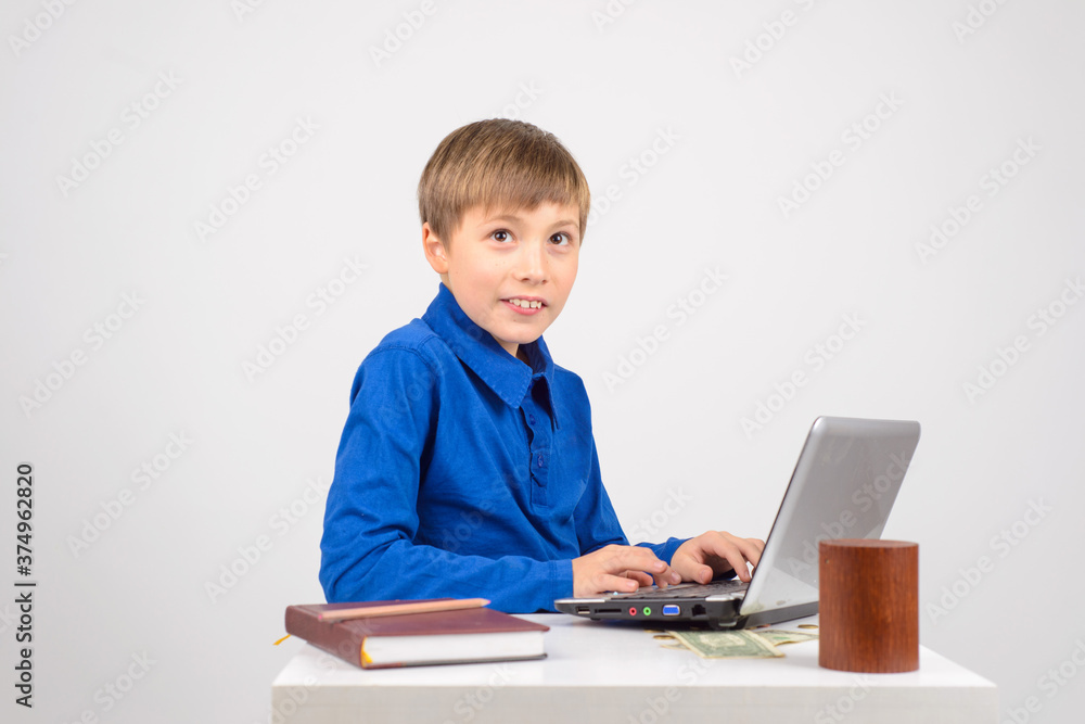 the young hacker: a Young smart boy with a netbook recklessly happy with his Affairs the young hacker: a Young smart boy with a netbook recklessly happy with his Affairs