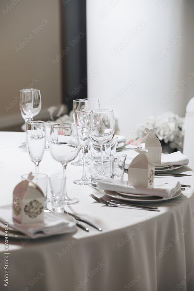 Fototapeta premium tableware Glasses, flower fork, knife served for dinner in restaurant with cozy interior