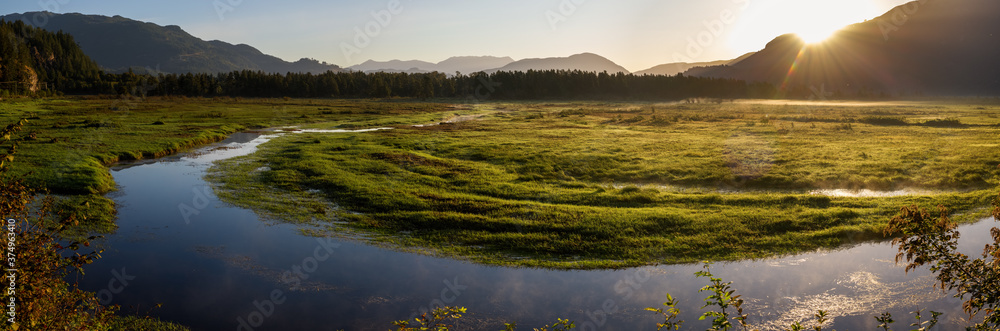 Panorama of marshlands, mountains in early summer sunrise