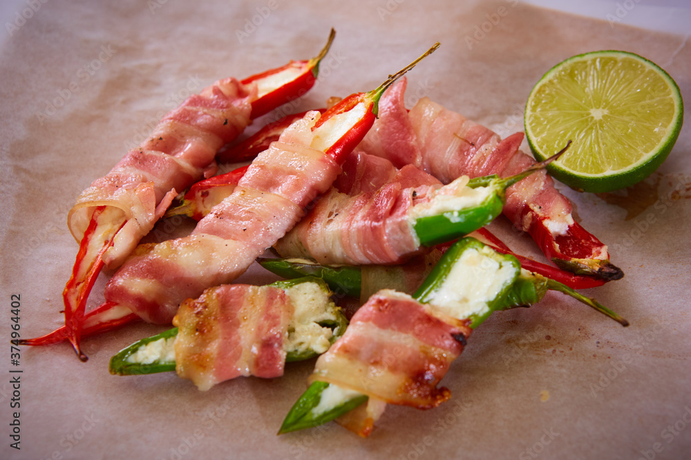 Jalapeno poppers wrapped in bacon stuffed with cheese seasoned with herbs and spices, top view. Shallow dof. Jalapeno poppers wrapped in bacon stuffed with cheese seasoned with herbs and spices, top view. Shallow dof.