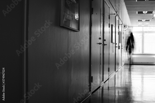 Unrecognizable person in motion blur in an abandoned hospital corridor