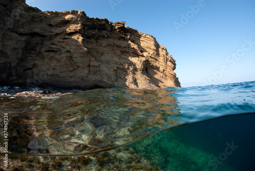Split shot of a rocky island with clear waters and a blue sky.