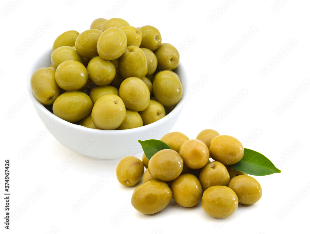 pickled green olives in a bowl and olive tree branch on a white background