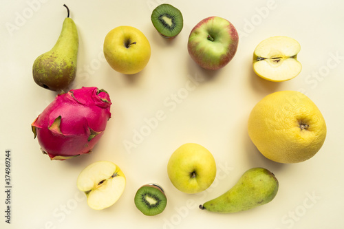 Fototapeta Naklejka Na Ścianę i Meble -  A variety of colourful fresh fruit on a yellow background shot from above with copy space