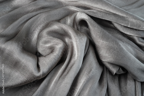 Background from a gray flowing glossy silk fabric. Fabric texture.