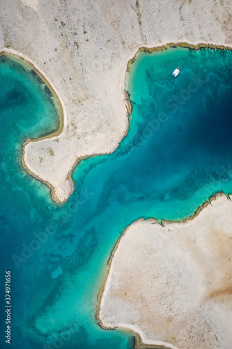 Aerial view of the shoreline surrounded by turquoise water in Vlasici, Pag, Croatia photo