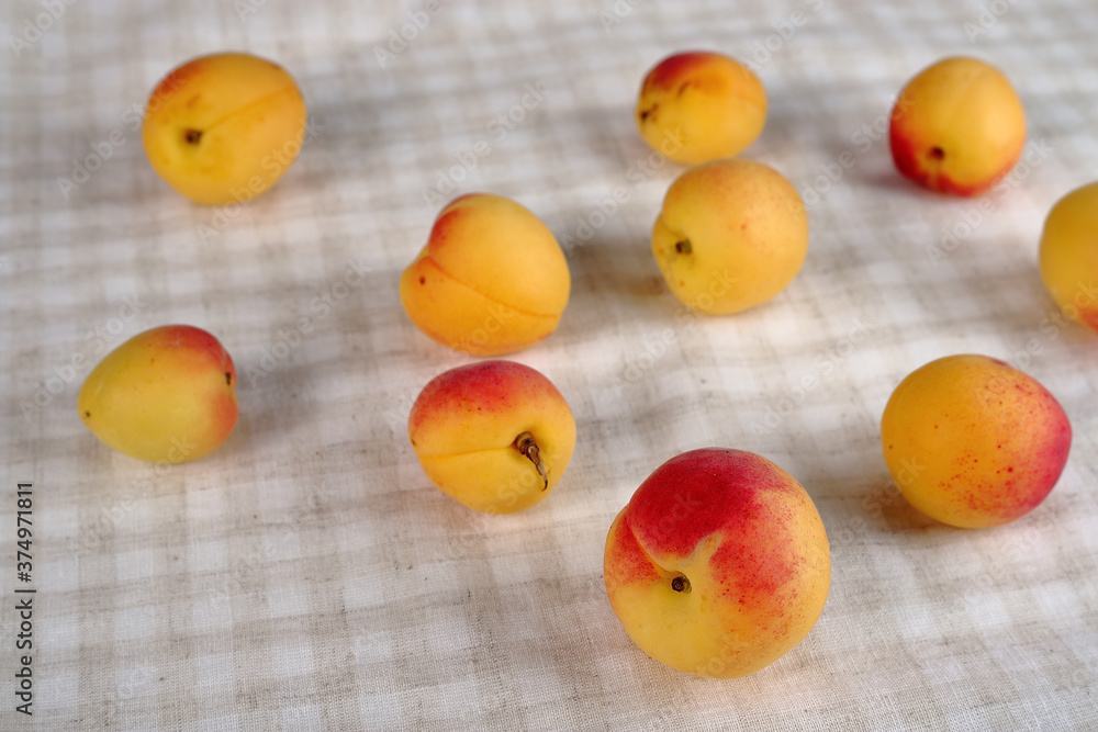 Juicy apricots on a checkered cotton background. Juicy apricots on a checkered cotton background.