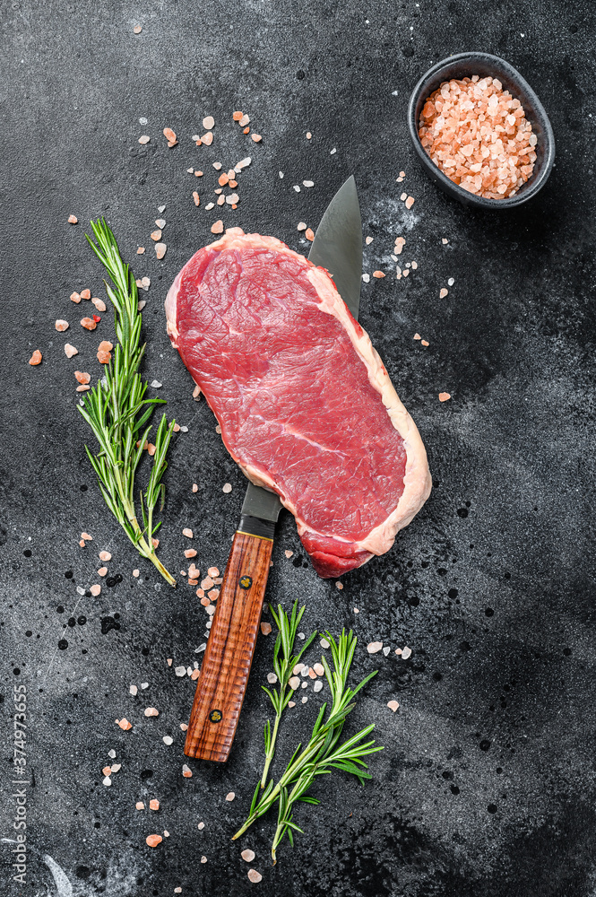 Striploin, strip loin steak or new York. Raw beef. Black background. Top view