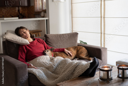 young woman relaxing on sofa with his dog