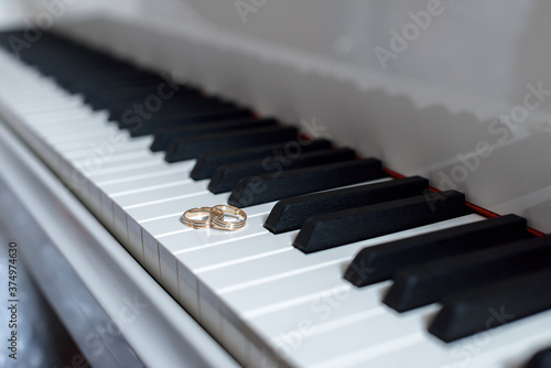 Wallpaper Mural Two gold rings lie on the keys of white piano. Torontodigital.ca