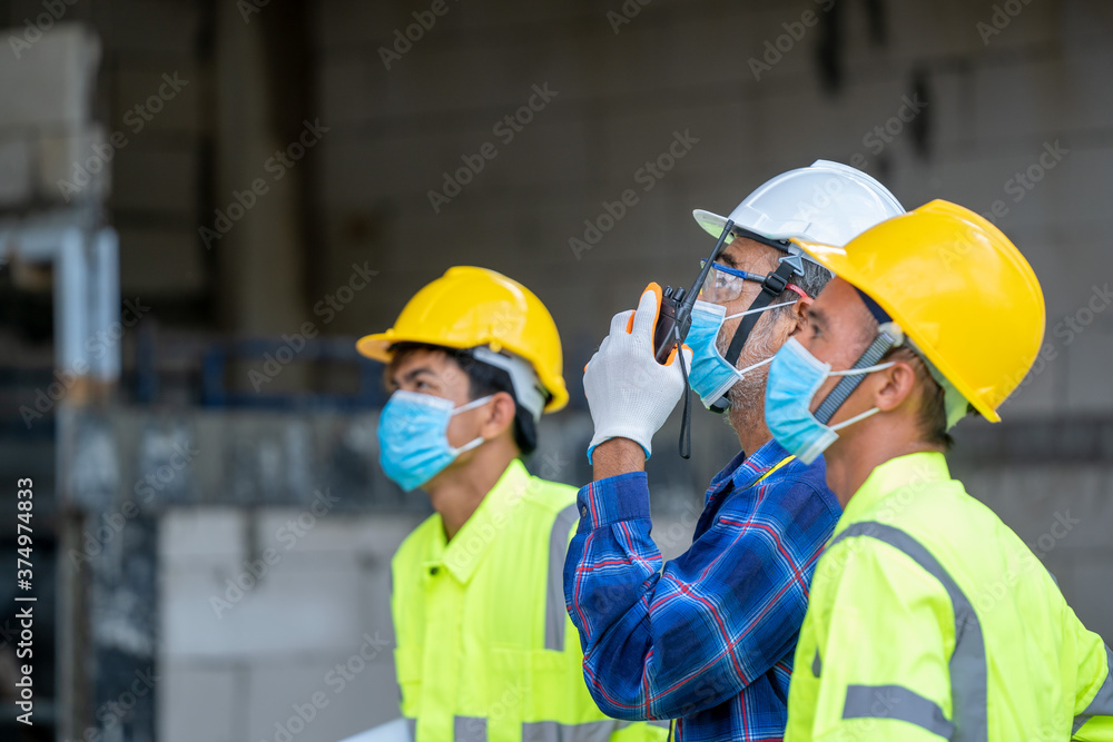 Engineer group wearing protective mask to Protect Against Covid-19 use radio communications to communicate for work safety. Engineer group wearing protective mask to Protect Against Covid-19 use radio communications to communicate for work safety.