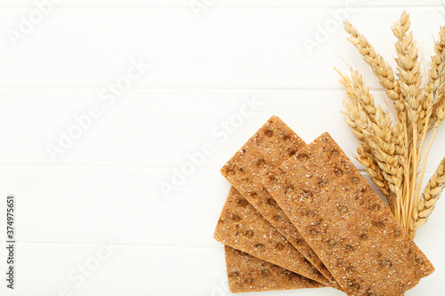 Canvas Print Rye crispbread with wheat ears on white wooden table