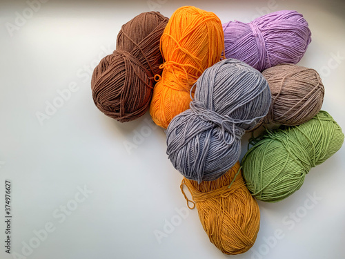 Colored yarn for knitting on a white background. Photo from above. Crocheting and knitting, needlework. The concept of creating products.