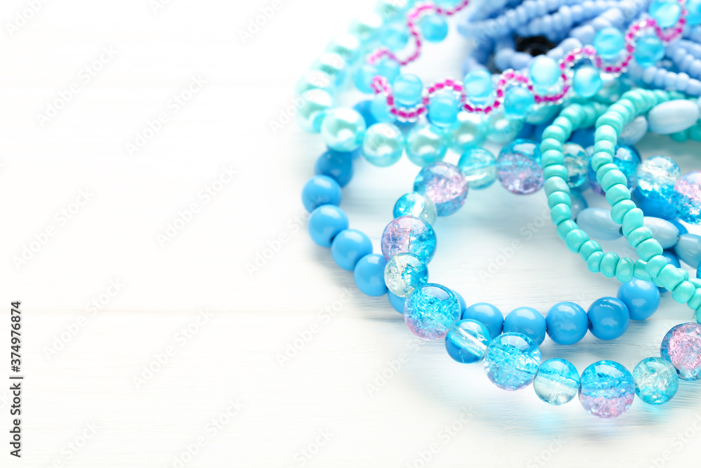 Beautiful blue bracelets on white wooden background Beautiful blue bracelets on white wooden background