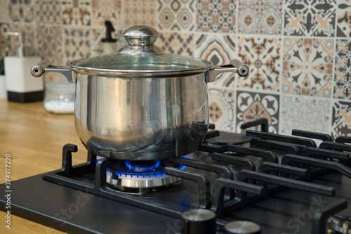 Cooking on a gas stove. The pot on gas burner.
