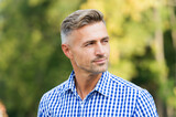 casual business fashion. male beauty and fashion. mature handsome man outdoor. well groomed man looking away. confident guy wear checkered shirt. unshaven male has graying hair