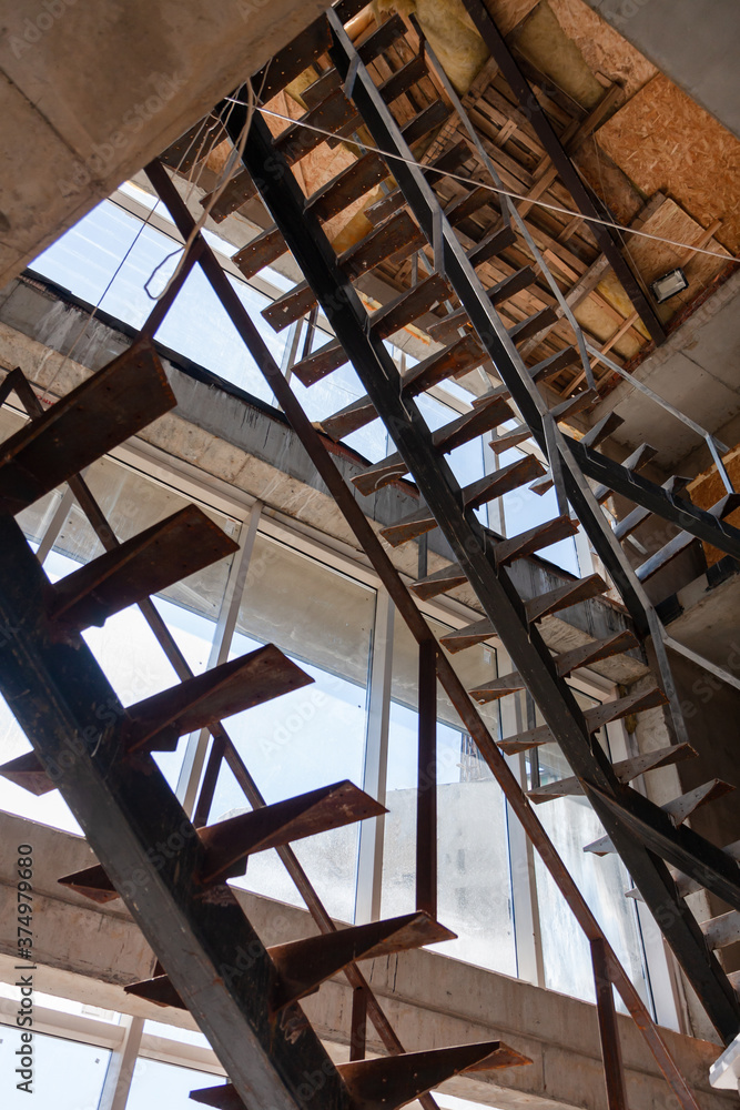 Obraz premium Interior of a construction site of a multi-storey building. Installation of steel stairs using steel i-beams.