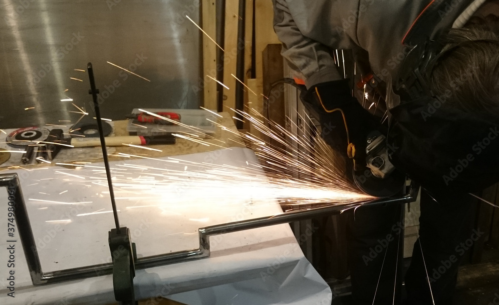 Mechanic at work in the process of grinding metal Mechanic at work in the process of grinding metal