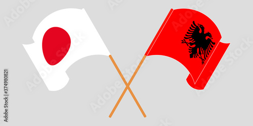 Crossed and waving flags of Albania and Japan