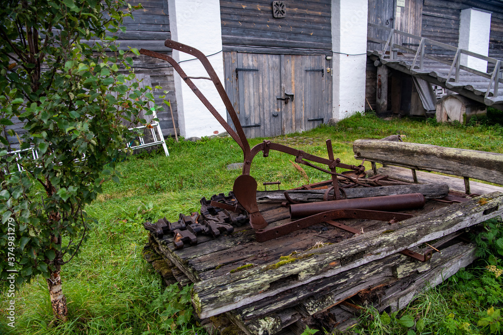 antique iron plow for arable land on a wooden platform antique iron plow for arable land on a wooden platform