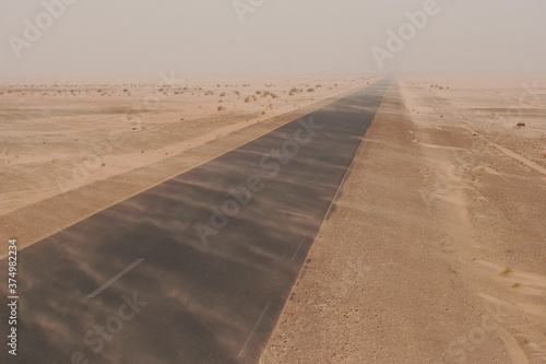 Dust plumes across the road in sandstorm at Sahara