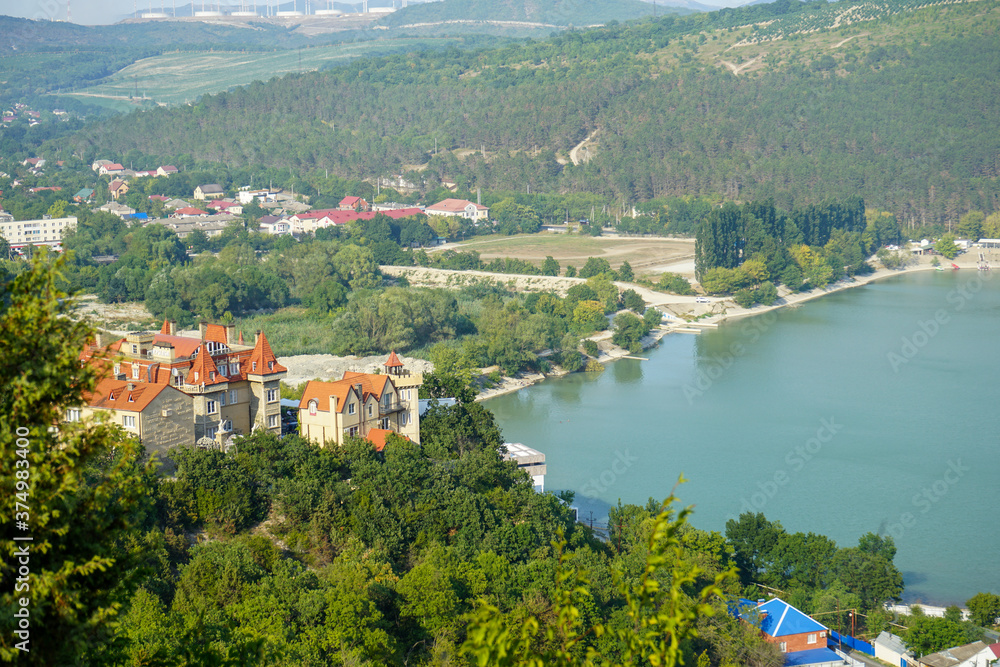 a beautiful castle immersed in the dense green vegetation of the mountains on the Abrau Durso lake on a clear summer day