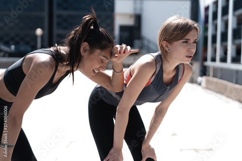 Two female friends relax after running in city
