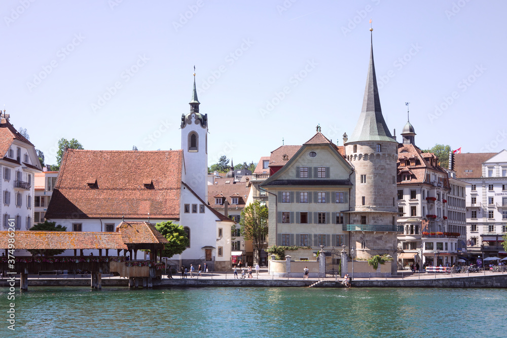Cityscape of Lucerne, riverbank with old architecture, unrecognisable people. Switzerland.