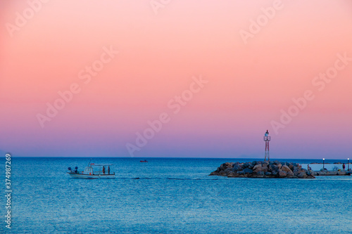 Sunset on Chios Island in Greece while a boat leaving the port