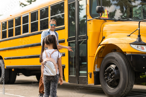 Smiling bus driver looking at camera outside the elementary school