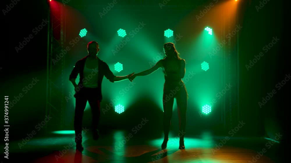Concept of social dance and relationships. Silhouette of young beautiful couple dancing sensual dance salsa. Concept of social dance and relationships. Silhouette of young beautiful couple dancing sensual dance salsa.