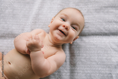 Newborn baby three months old smiles and lies. Psychomotor development and baby care photo