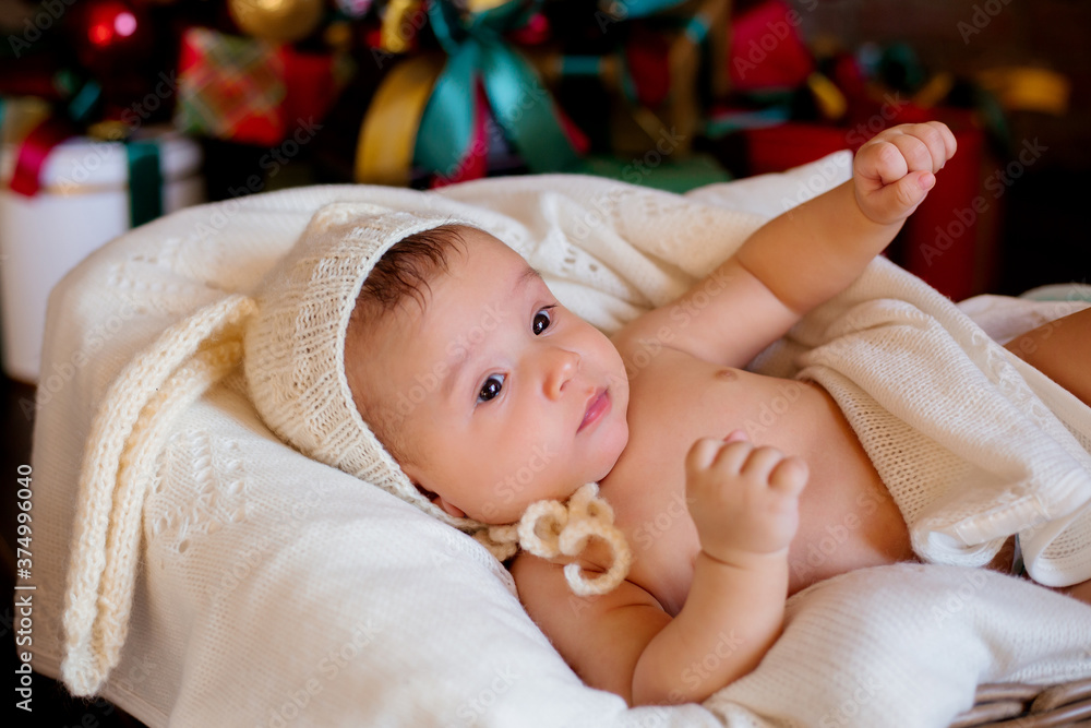 Newborn baby lies in a white cocoon in a rabbit hat Newborn baby lies in a white cocoon in a rabbit hat