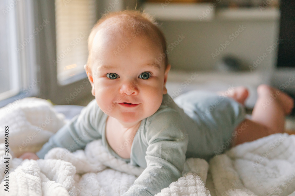 A three-month-old baby lies on his stomach A three-month-old baby lies on his stomach