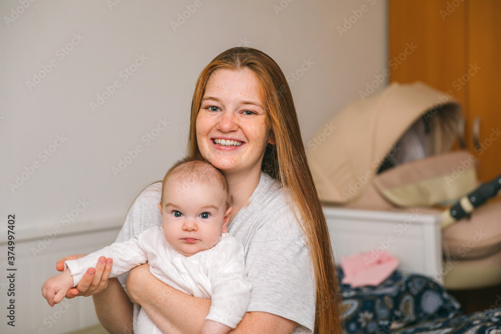 Mother hugs with her newborn three month old baby in the bedroom