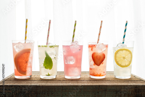 Five varieties of lemonade with colored straws photo