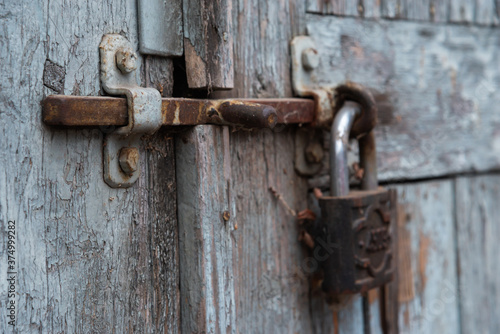 old rusty lock on the door in an abandoned house close-up