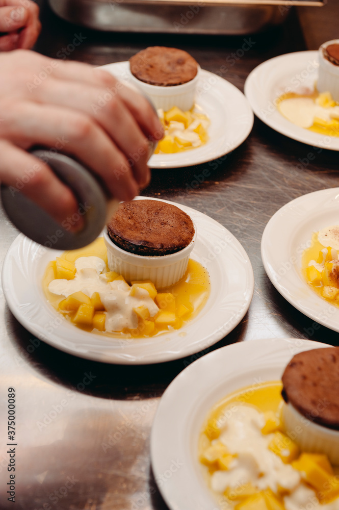 Hot brownie chocolate cake dessert with mango fruits and vanilla cream Hot brownie chocolate cake dessert with mango fruits and vanilla cream