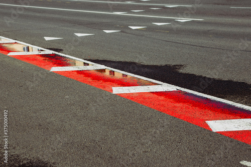 Asphalt road top view with red line texture background. road signs on the road © Lena
