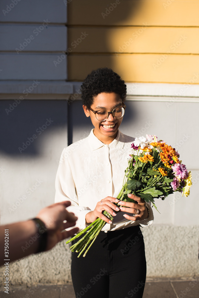 Smiling woman receiving a bouquet of flowers Smiling woman receiving a bouquet of flowers