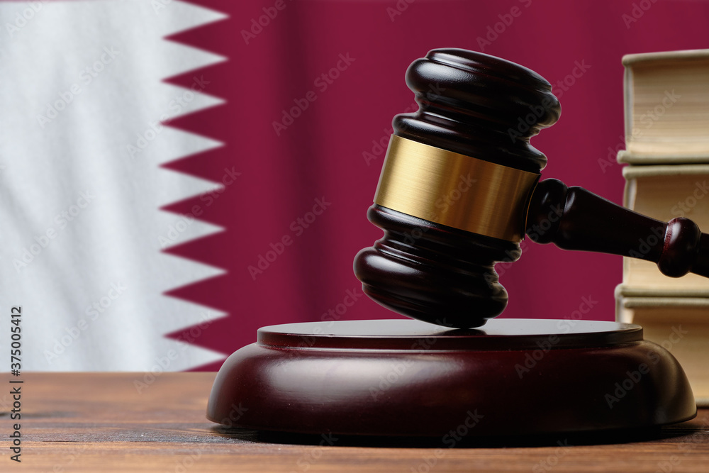 Justice and court concept in State of Qatar. Judge hammer on a flag background